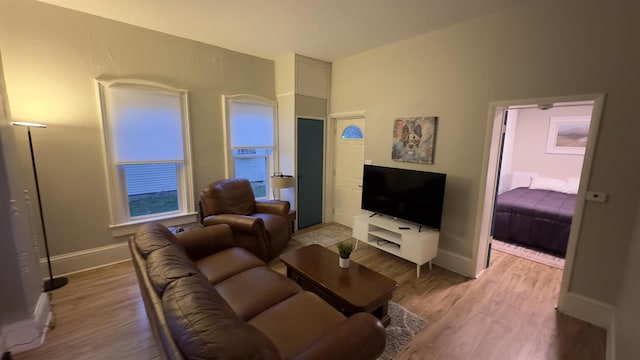 living area featuring light wood-style floors and baseboards