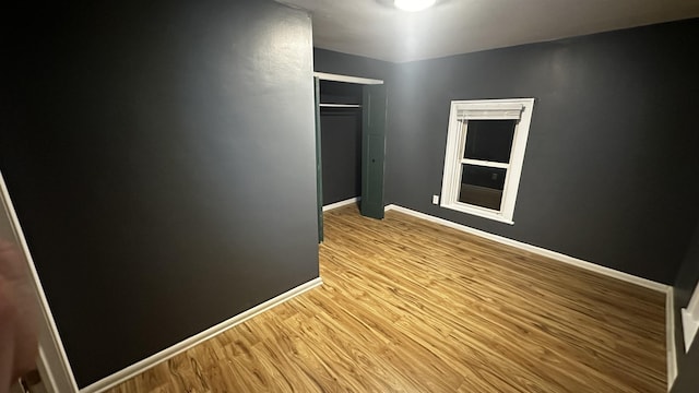 unfurnished room featuring light wood-type flooring and baseboards