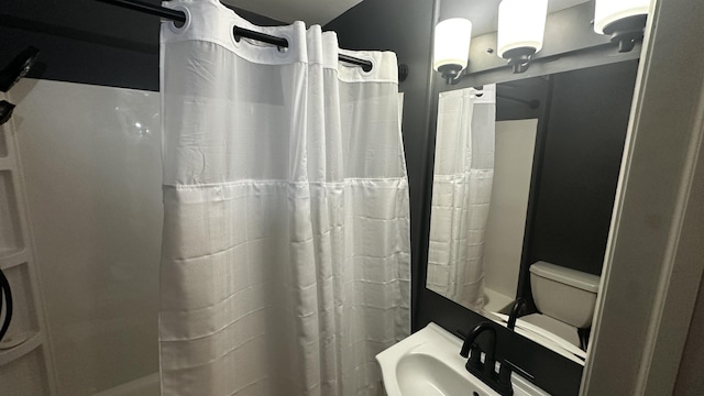 bathroom with curtained shower and a sink