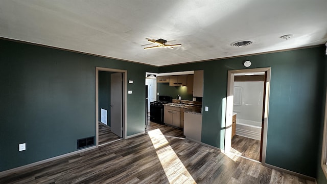 kitchen with black gas range, visible vents, dark wood-type flooring, and a sink