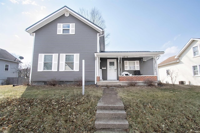 traditional-style house with brick siding, central AC unit, a porch, and a front yard