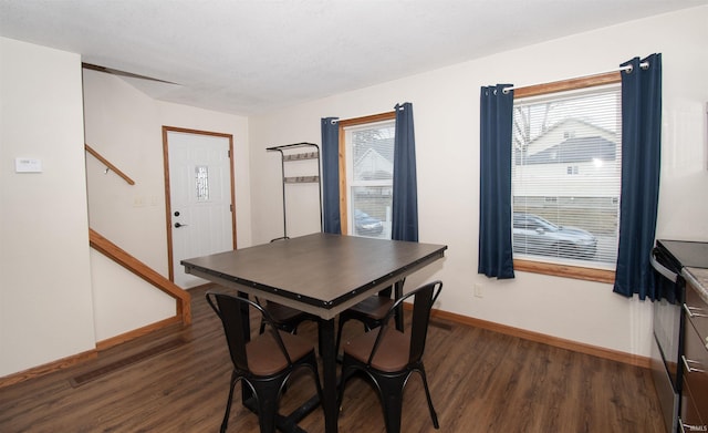 dining space featuring stairway, baseboards, and wood finished floors