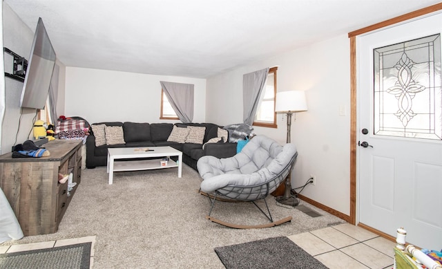 living area with light tile patterned floors, visible vents, and baseboards