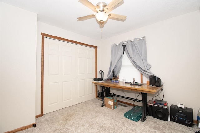 carpeted home office featuring baseboards and a ceiling fan