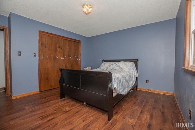 bedroom with a closet, wood finished floors, and baseboards