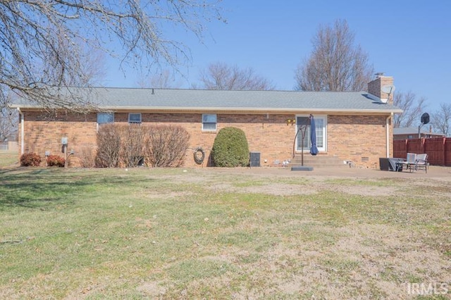 back of house with entry steps, a patio, a chimney, fence, and a yard