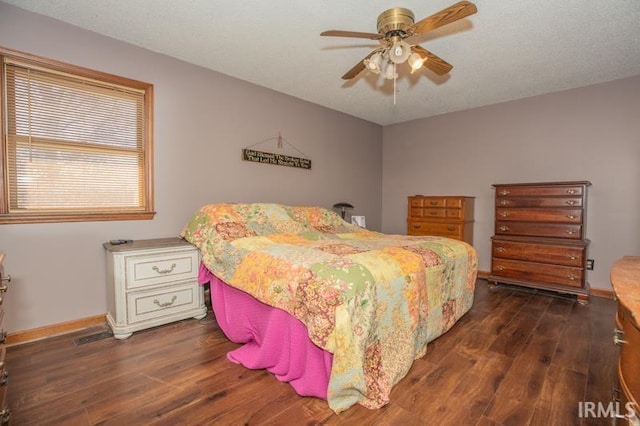 bedroom with ceiling fan, dark wood finished floors, and baseboards