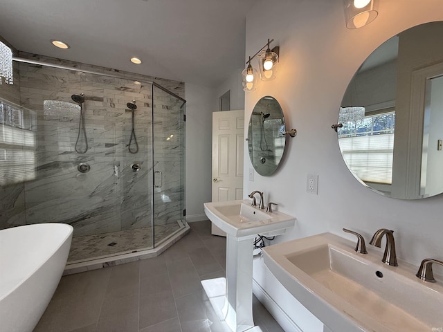 bathroom featuring a stall shower, a freestanding tub, two sinks, and recessed lighting