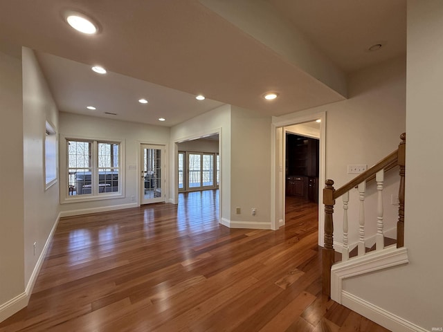 unfurnished room with baseboards, stairway, wood finished floors, and recessed lighting