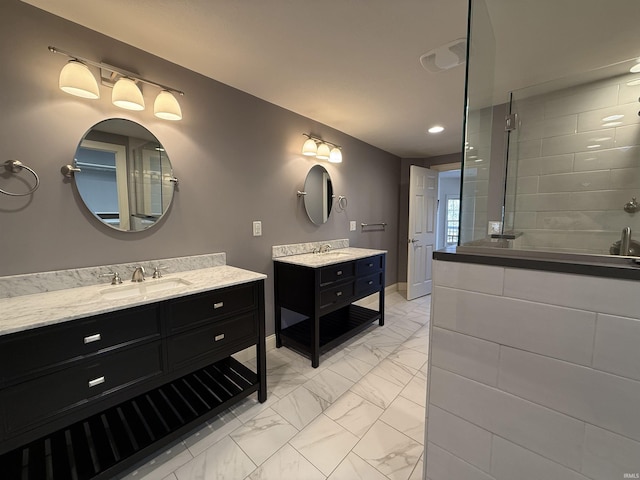 bathroom featuring marble finish floor, two vanities, a sink, tiled shower, and baseboards