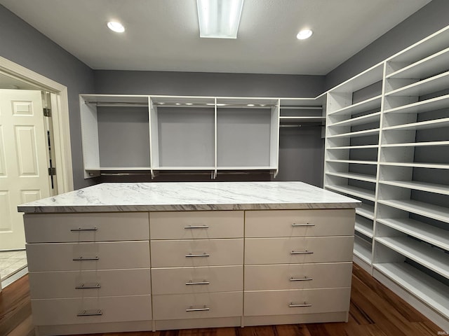 walk in closet with dark wood-type flooring