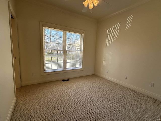 unfurnished room featuring baseboards, carpet, visible vents, and crown molding