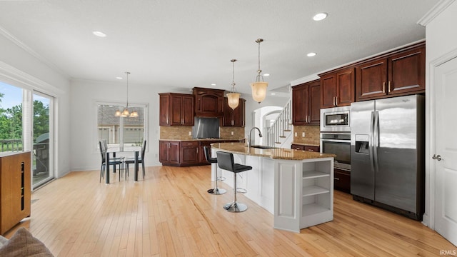 kitchen featuring a sink, appliances with stainless steel finishes, light wood-type flooring, open shelves, and crown molding