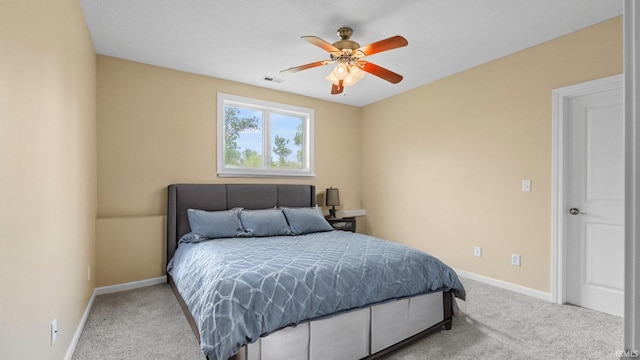 carpeted bedroom with a ceiling fan, visible vents, and baseboards