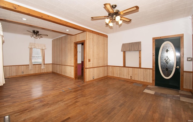 foyer entrance featuring visible vents, a ceiling fan, a wainscoted wall, hardwood / wood-style floors, and wood walls