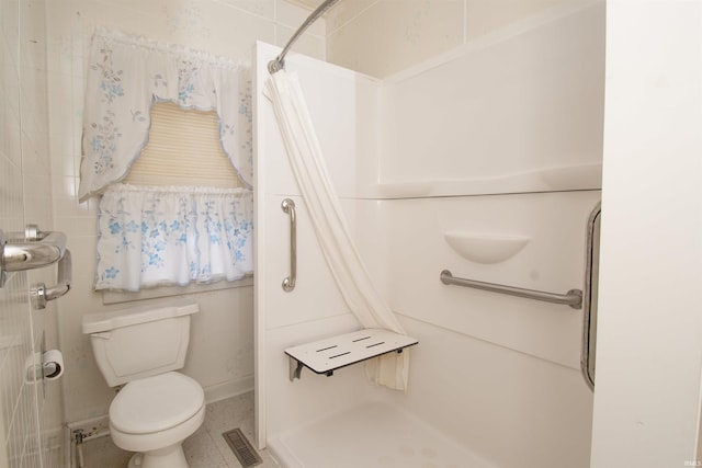 bathroom with visible vents, a shower, and toilet