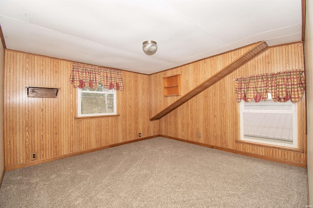 spare room featuring baseboards, carpet floors, and wooden walls