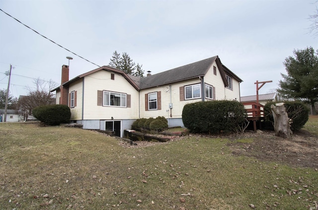 back of property featuring a lawn and a chimney