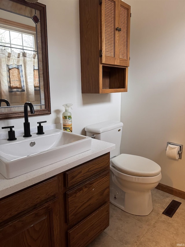 bathroom with baseboards, visible vents, toilet, tile patterned floors, and vanity