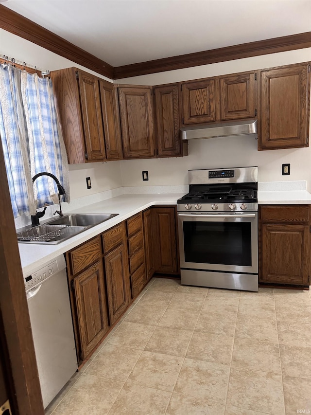 kitchen featuring appliances with stainless steel finishes, light countertops, under cabinet range hood, a sink, and light tile patterned flooring