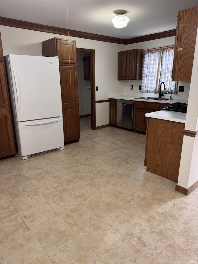 kitchen with ornamental molding, freestanding refrigerator, light countertops, stainless steel dishwasher, and a sink