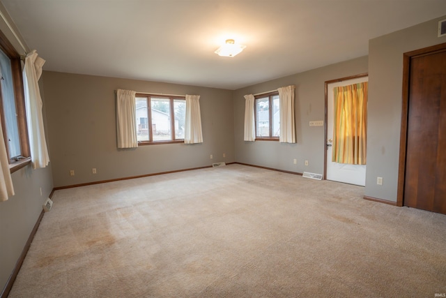 unfurnished bedroom with baseboards, visible vents, and light colored carpet