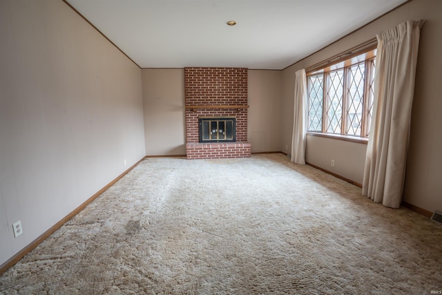 unfurnished living room with carpet, visible vents, a fireplace, and baseboards