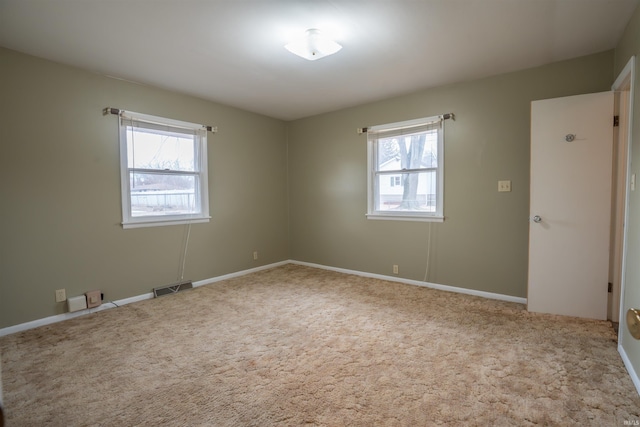 empty room featuring carpet floors and visible vents