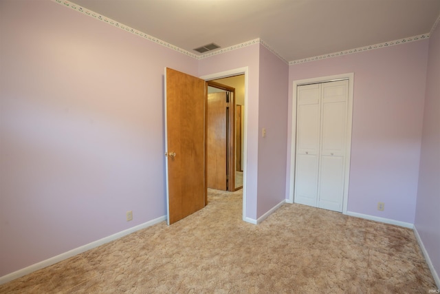 unfurnished bedroom with carpet floors, visible vents, and baseboards