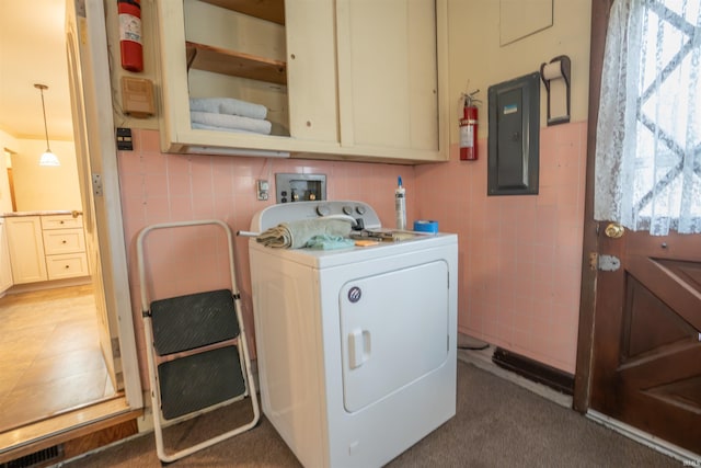 laundry room featuring visible vents, tile walls, cabinet space, electric panel, and washer / dryer