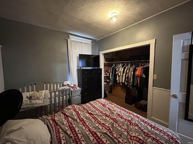 bedroom featuring a textured ceiling, a closet, and wood finished floors