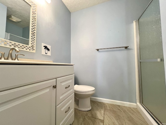 bathroom featuring baseboards, toilet, an enclosed shower, a textured ceiling, and vanity