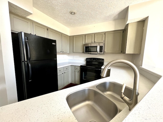 kitchen with a textured ceiling, a sink, light countertops, gray cabinets, and black appliances