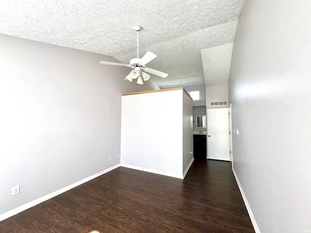 spare room with baseboards, visible vents, a ceiling fan, wood finished floors, and a textured ceiling