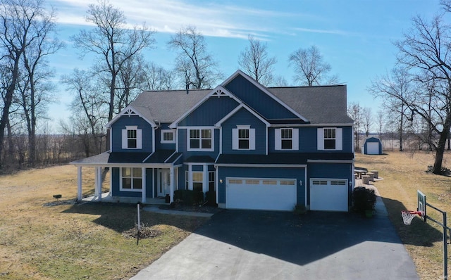 view of front of property with an attached garage, aphalt driveway, a porch, and a front yard