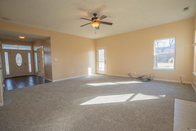 interior space with visible vents, carpet, a wealth of natural light, and baseboards