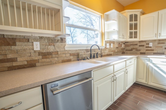 kitchen featuring backsplash, glass insert cabinets, wood tiled floor, a sink, and dishwasher