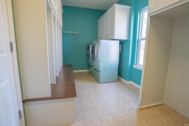 laundry room with cabinet space, baseboards, and separate washer and dryer