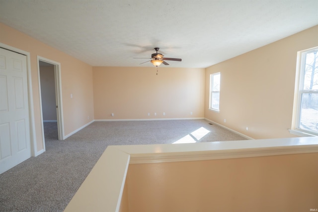 empty room with carpet, ceiling fan, and baseboards