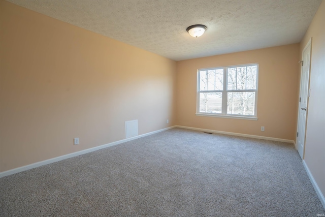 carpeted empty room featuring visible vents, a textured ceiling, and baseboards