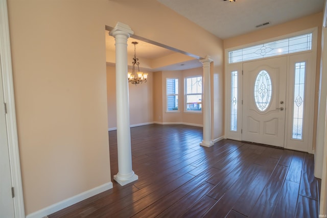 entrance foyer with visible vents, dark wood finished floors, decorative columns, and baseboards