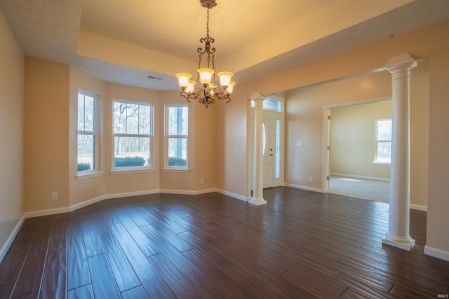 unfurnished room featuring dark wood-style flooring, a raised ceiling, baseboards, and ornate columns