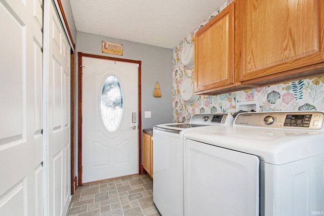 laundry area with a textured ceiling, stone finish flooring, independent washer and dryer, and cabinet space