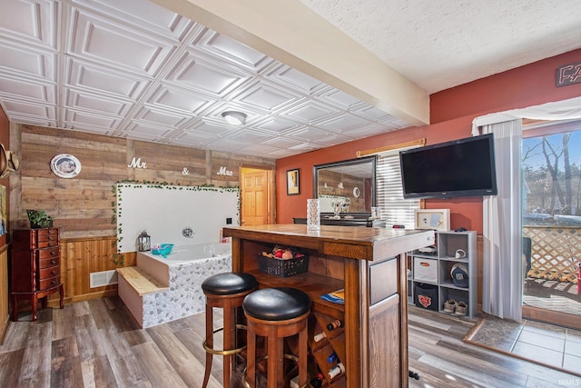 bar featuring visible vents, wood walls, wood finished floors, and an ornate ceiling