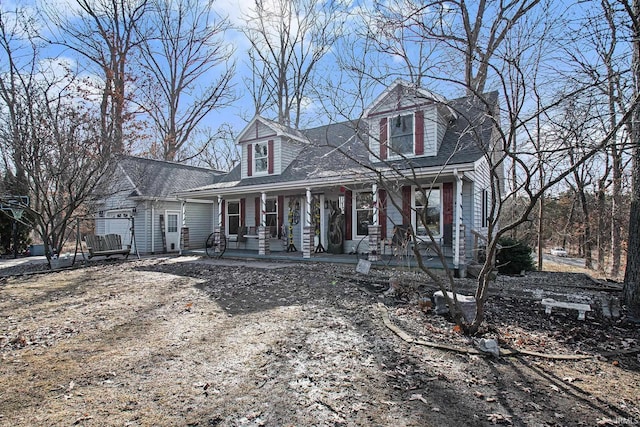 new england style home with a porch and roof with shingles