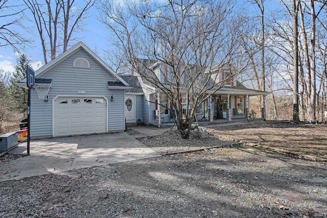 view of front of home featuring a garage, concrete driveway, and a porch