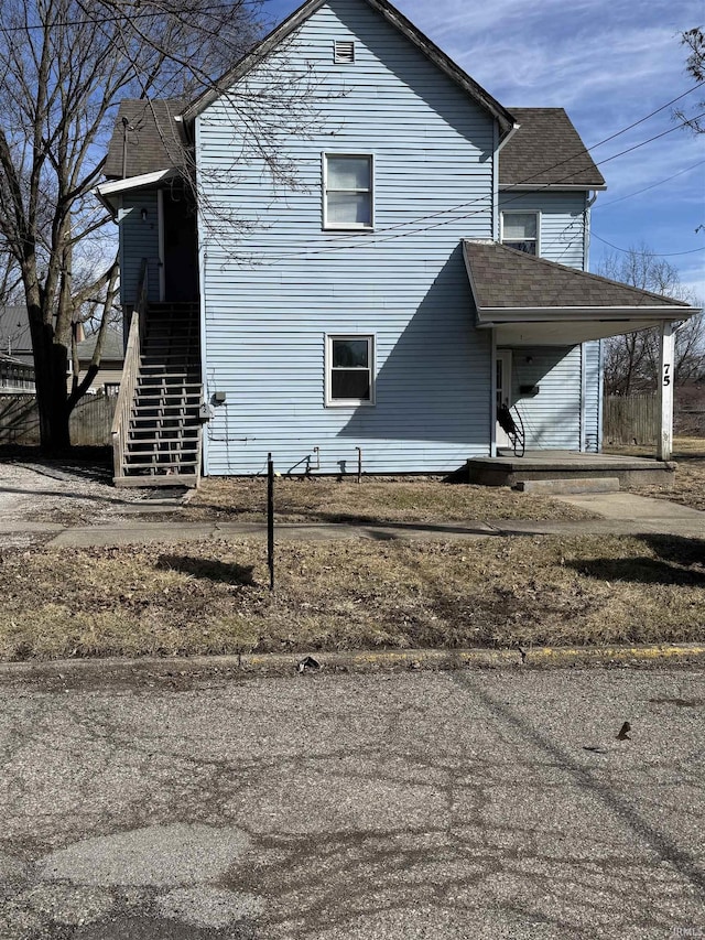 view of side of home featuring stairway