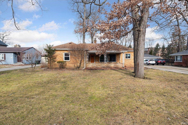 single story home with brick siding, a chimney, and a front lawn