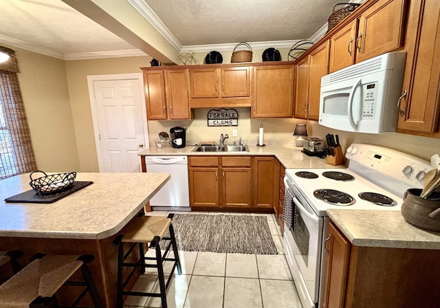 kitchen featuring white appliances, a sink, and brown cabinets