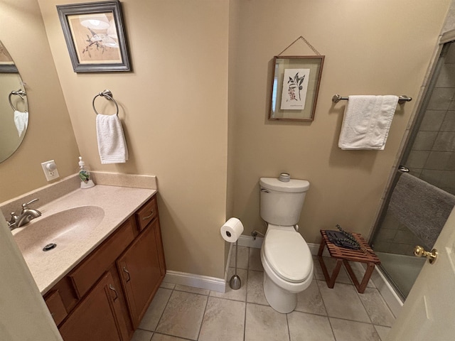 full bathroom with toilet, vanity, baseboards, tiled shower, and tile patterned floors